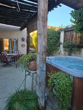 a kitchen with stainless steel appliances granite countertop a dining table chairs refrigerator and microwave