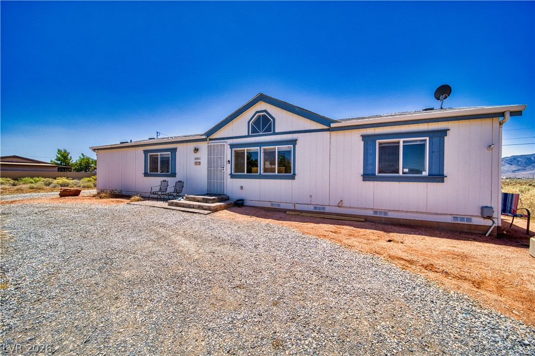 2931 Rio Rancho Drive, Unit 4 Pahrump, NV 89048 - Photo 18 of 21 A desert oasis with a charming facade, featuring an inviting gravel driveway and distinct window accents.