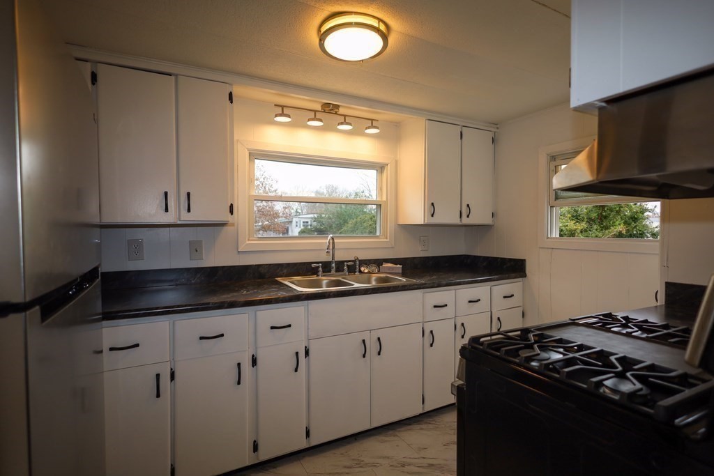 26 Claudia Street Wareham, MA 02538 - Photo 5 of 17 a kitchen with granite countertop white cabinets and a stove top oven
