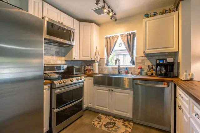 a kitchen with a stove a sink and a window