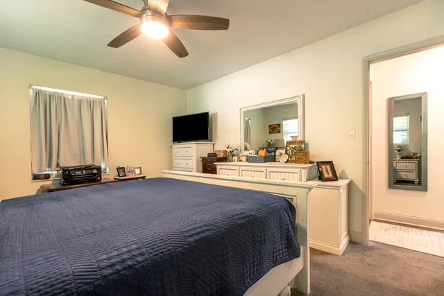 a spacious bedroom with a bed and a flat screen tv