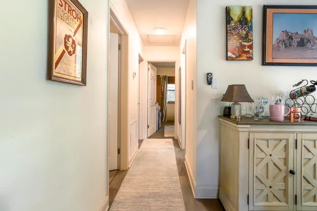 a view of a hallway view with wooden floor and cabinets