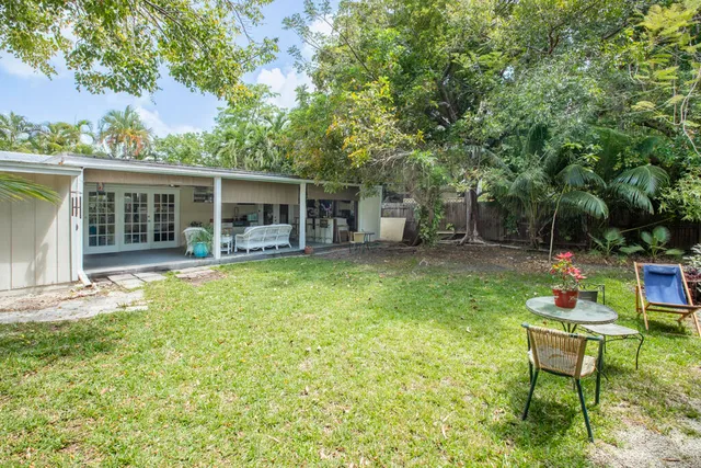 a backyard of a house with table and chairs