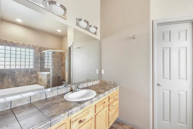a bathroom with a granite countertop sink and a mirror