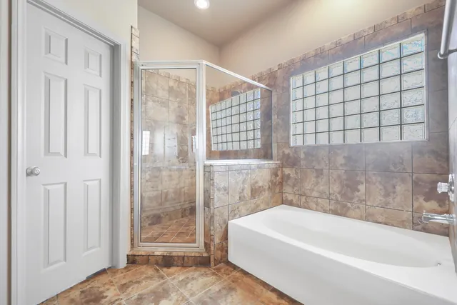 a bathroom with a bathtub and next to a window