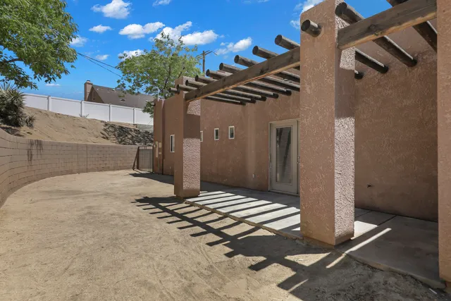 a vase of flowers sitting on a floor in front of a house