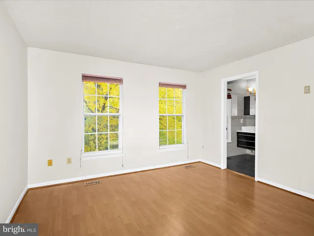 an empty room with a window and wooden floor