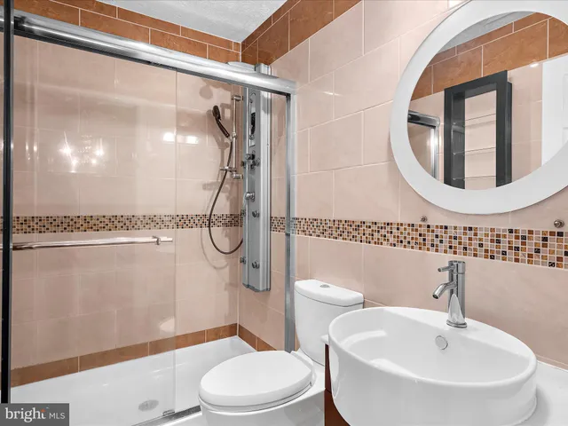 a bathroom with a toilet a sink and a mirror