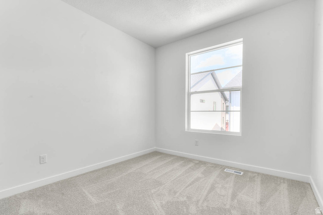 3204 West 1570 North Provo, UT 84601 - Photo 15 of 19 Empty room with light colored carpet and a textured ceiling