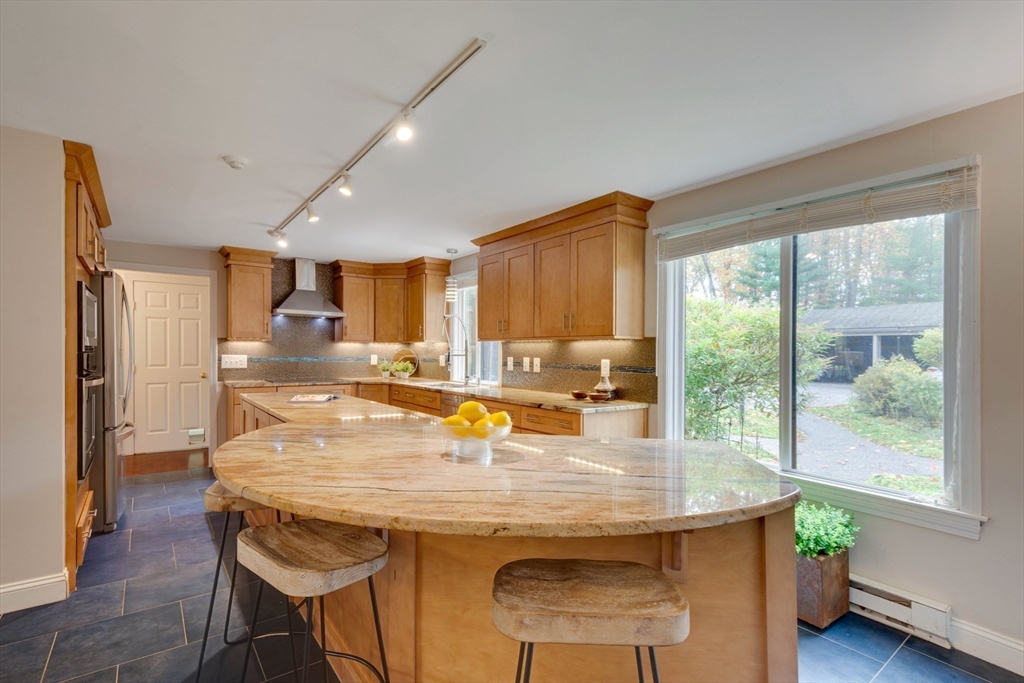 134 Chestnut Circle, Unit 134 Lincoln, MA 01773 - Photo 12 of 38 a dining room with stainless steel appliances granite countertop a sink a table and chairs