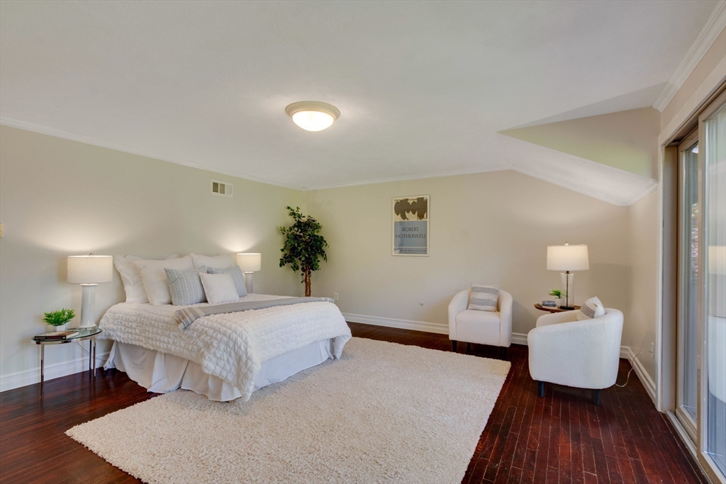 134 Chestnut Circle, Unit 134 Lincoln, MA 01773 - Photo 17 of 38 a bedroom with a bed and wooden floor