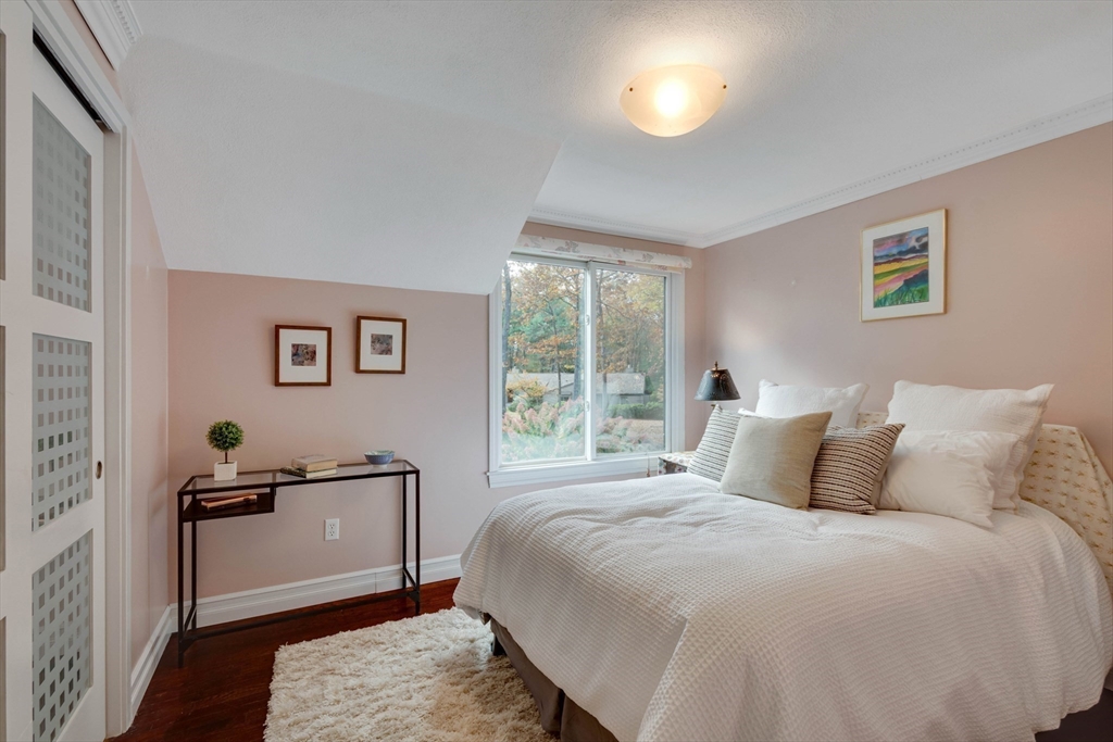 134 Chestnut Circle, Unit 134 Lincoln, MA 01773 - Photo 20 of 38 a bedroom with a bed and wooden floor