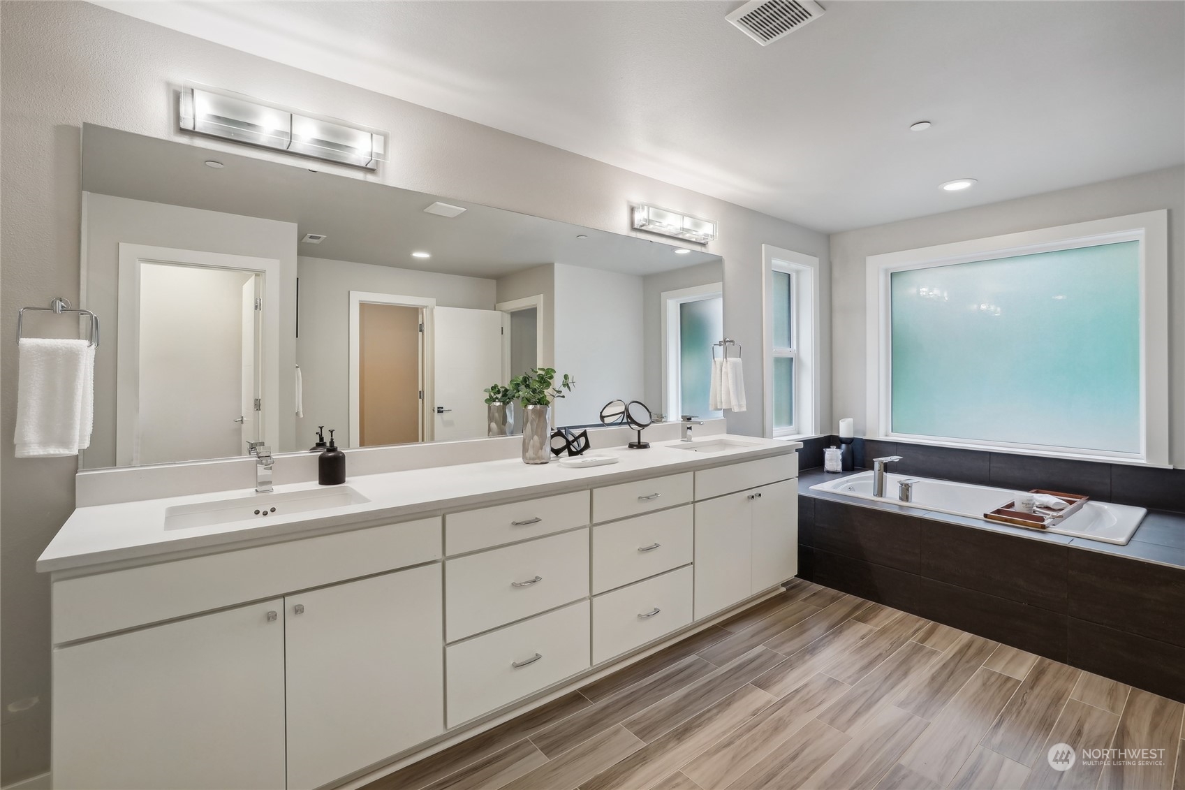 9933 Northeast 162nd Street Bothell, WA 98011 - Photo 22 of 40 a spacious bathroom with double vanity and a large mirror