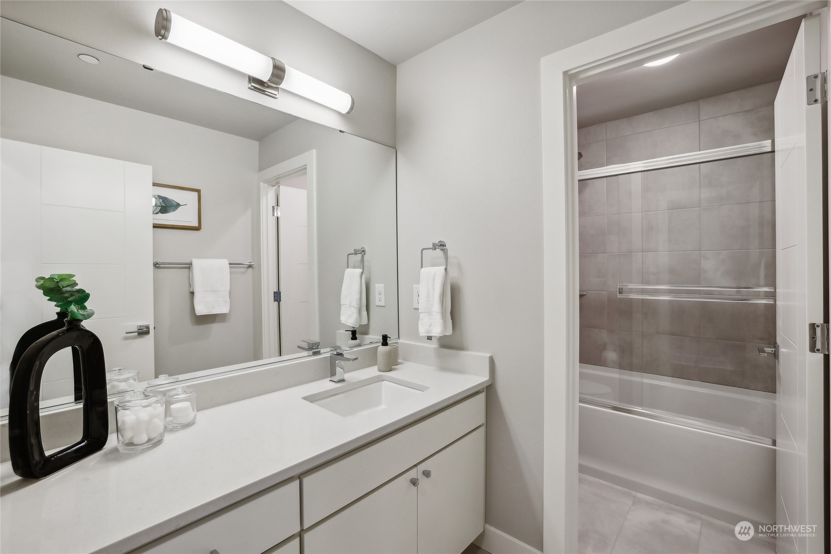 9933 Northeast 162nd Street Bothell, WA 98011 - Photo 26 of 40 a bathroom with a sink a faucet a mirror and a shower