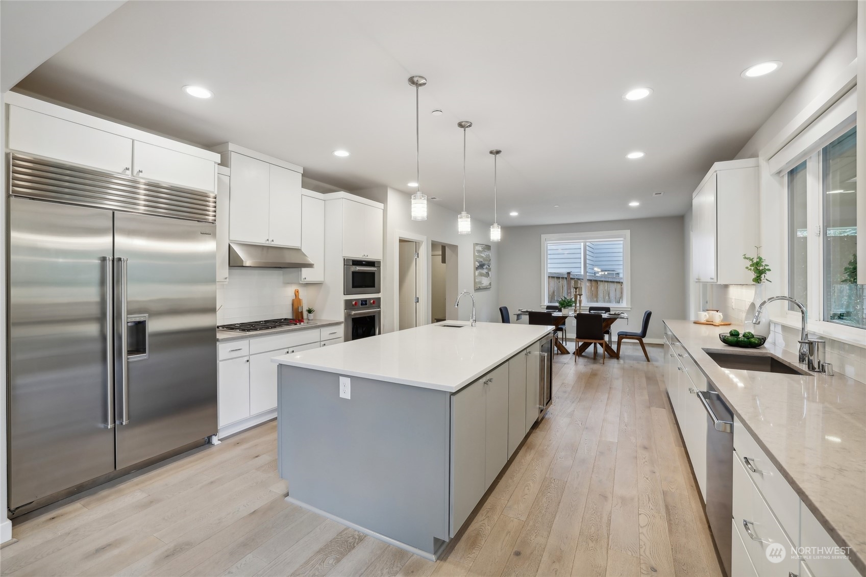 9933 Northeast 162nd Street Bothell, WA 98011 - Photo 10 of 40 a large kitchen with stainless steel appliances kitchen island a large counter top a sink a stove a refrigerator and cabinets