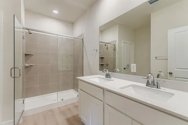 a bathroom with a shower sink and mirror
