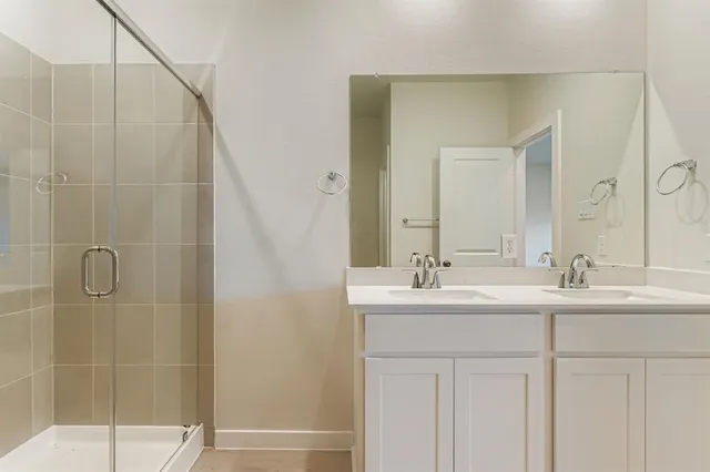 a bathroom with a double vanity sink and mirror