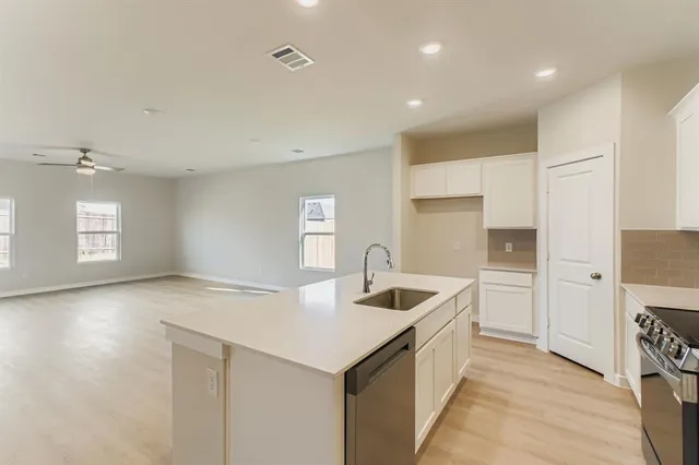 a kitchen with counter top space and windows