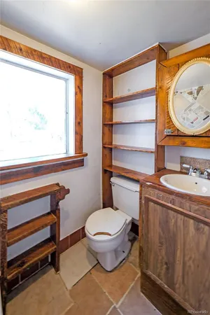 a bathroom with a toilet a sink and a mirror