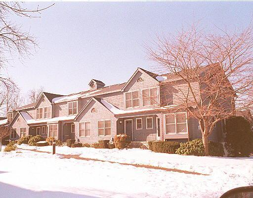 90 Fawn Ridge Lane, Unit 90 Norwalk, CT 06851 - Photo 1 of 1 a view of a white house with a yard covered in snow