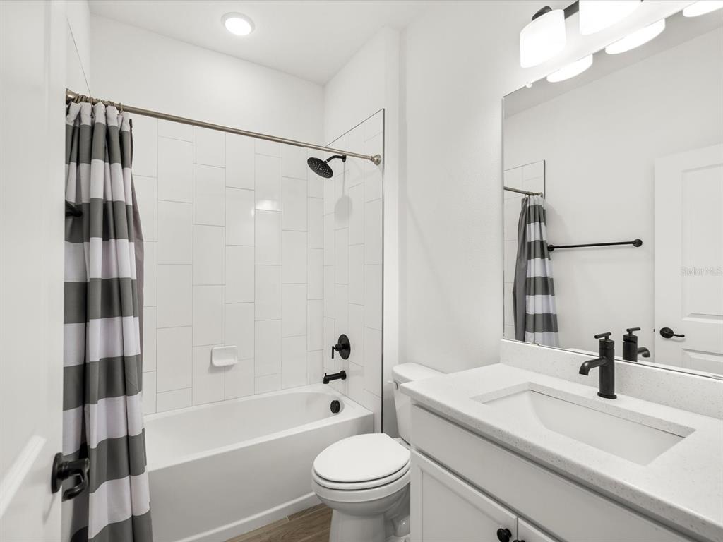 5219 Cappleman Loop Brooksville, FL 34601 - Photo 12 of 60 a bathroom with a sink a toilet a mirror and shower