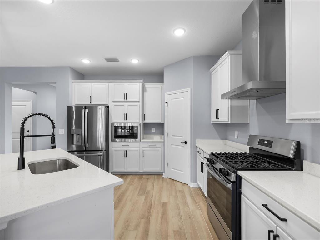 5219 Cappleman Loop Brooksville, FL 34601 - Photo 13 of 60 a kitchen with stainless steel appliances granite countertop a sink stove and refrigerator