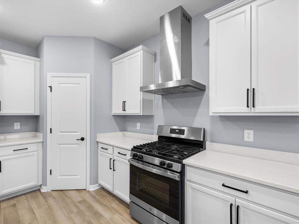 5219 Cappleman Loop Brooksville, FL 34601 - Photo 15 of 60 a kitchen with white cabinets and appliances