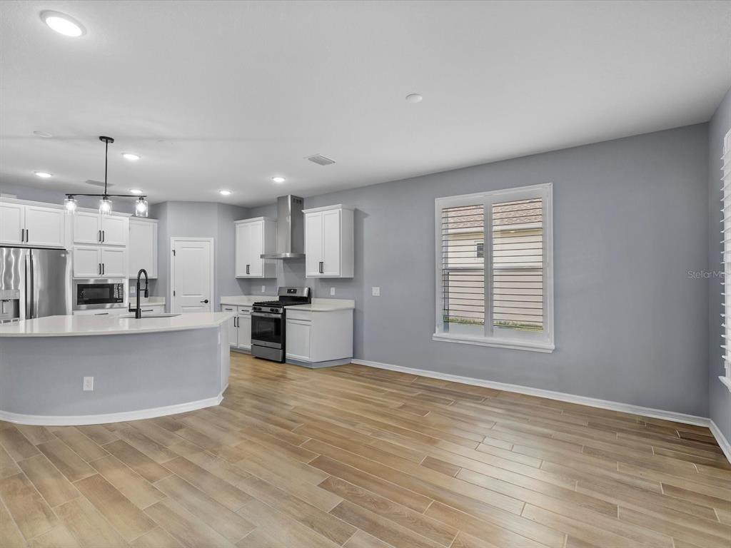 5219 Cappleman Loop Brooksville, FL 34601 - Photo 18 of 60 a view of kitchen with kitchen island a sink wooden floor and a stove