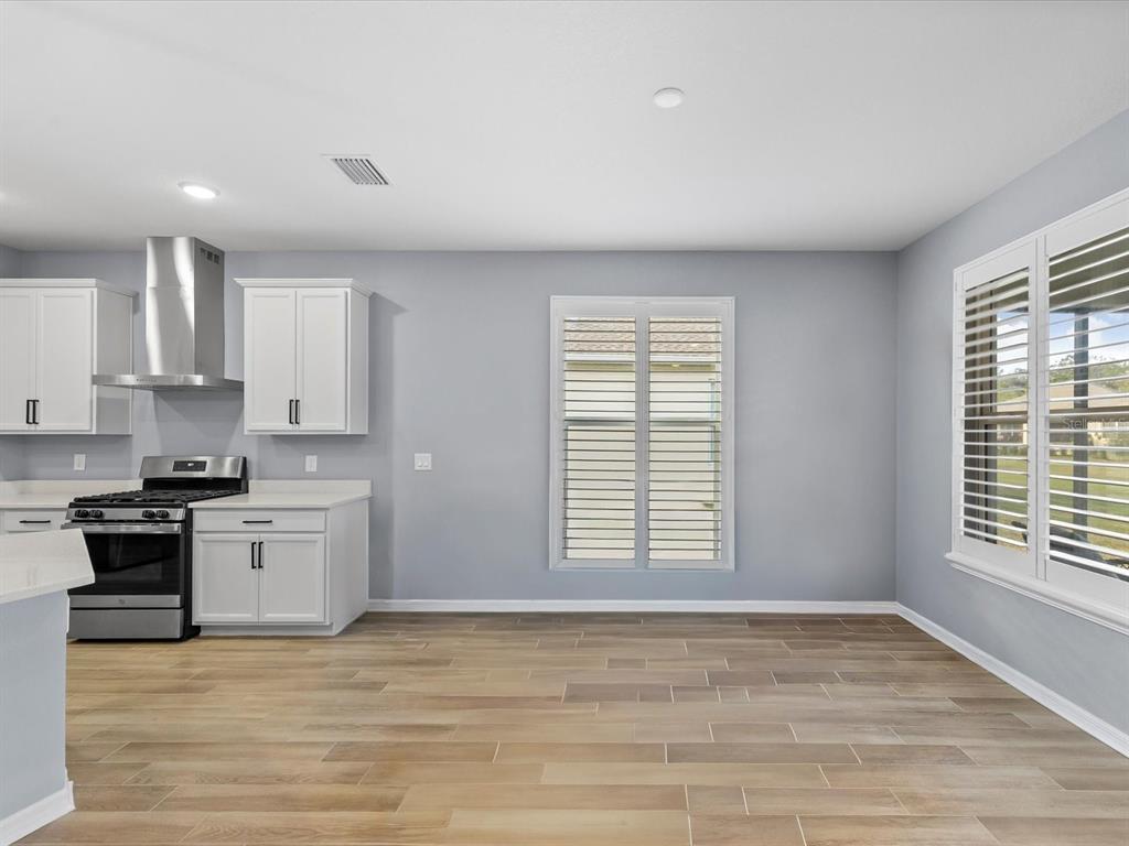 5219 Cappleman Loop Brooksville, FL 34601 - Photo 19 of 60 a view of a kitchen with a stove cabinets and wooden floor