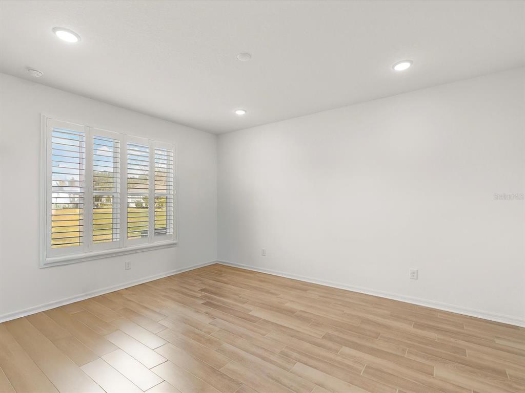 5219 Cappleman Loop Brooksville, FL 34601 - Photo 20 of 60 a view of an empty room with wooden floor and a window