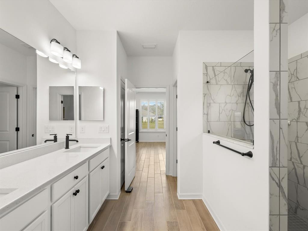 5219 Cappleman Loop Brooksville, FL 34601 - Photo 24 of 60 a spacious bathroom with a double vanity sink a mirror and shower