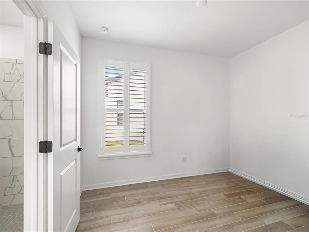 5219 Cappleman Loop Brooksville, FL 34601 - Photo 28 of 60 a view of an empty room with wooden floor and a window