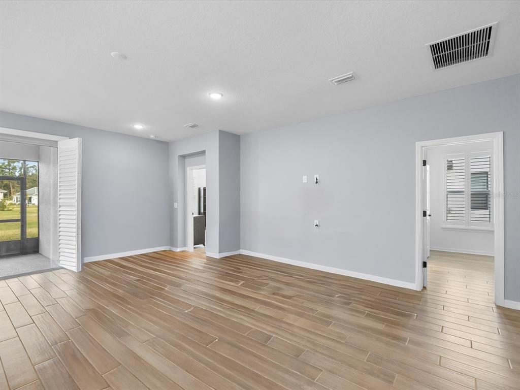 5219 Cappleman Loop Brooksville, FL 34601 - Photo 29 of 60 a view of an empty room with wooden floor and a window