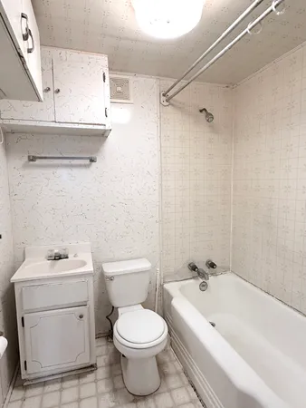 a white toilet sitting next to a bath tub