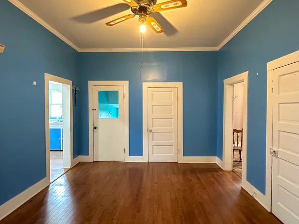 a view of an empty room with window and wooden floor