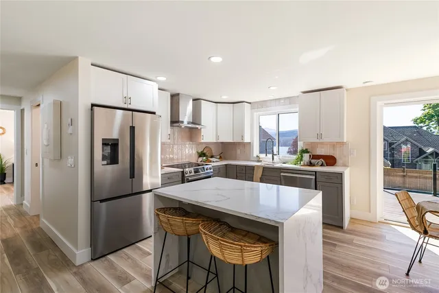 a kitchen with refrigerator a sink and chairs