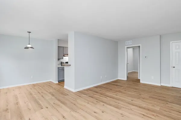 a view of empty room with wooden floor