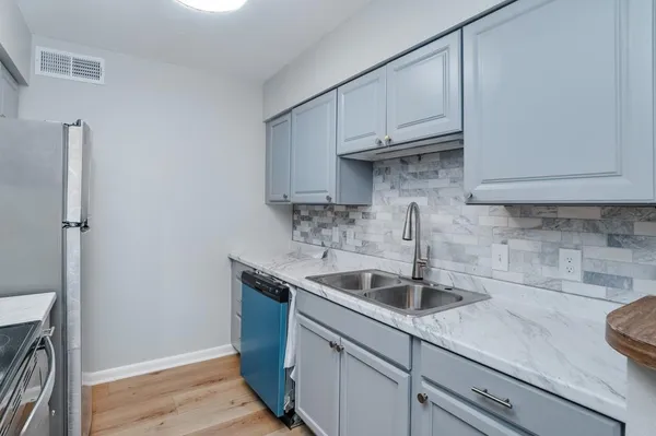 a kitchen with stainless steel appliances granite countertop a sink a refrigerator and cabinets