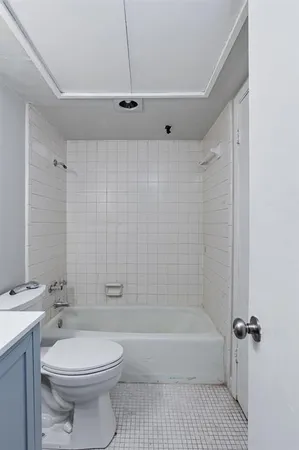 a bathroom with a toilet a sink a mirror and shower