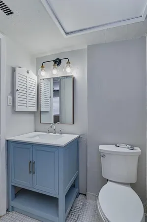 a bathroom with a toilet sink and mirror