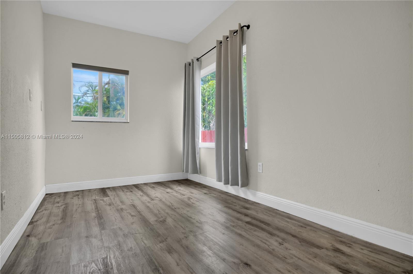 2043 Southwest 7th Street Miami, FL 33135 - Photo 27 of 37 a view of an empty room with wooden floor and a window