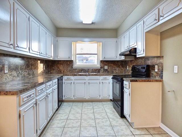20 Ford Road Phenix City, AL 36869 - Photo 6 of 15 a kitchen with stainless steel appliances granite countertop a stove a sink and a microwave