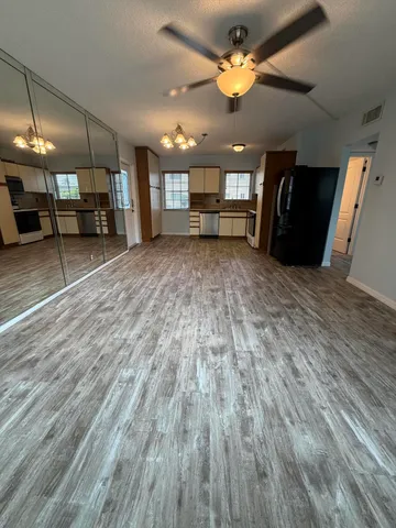 a view of an empty room with a kitchen