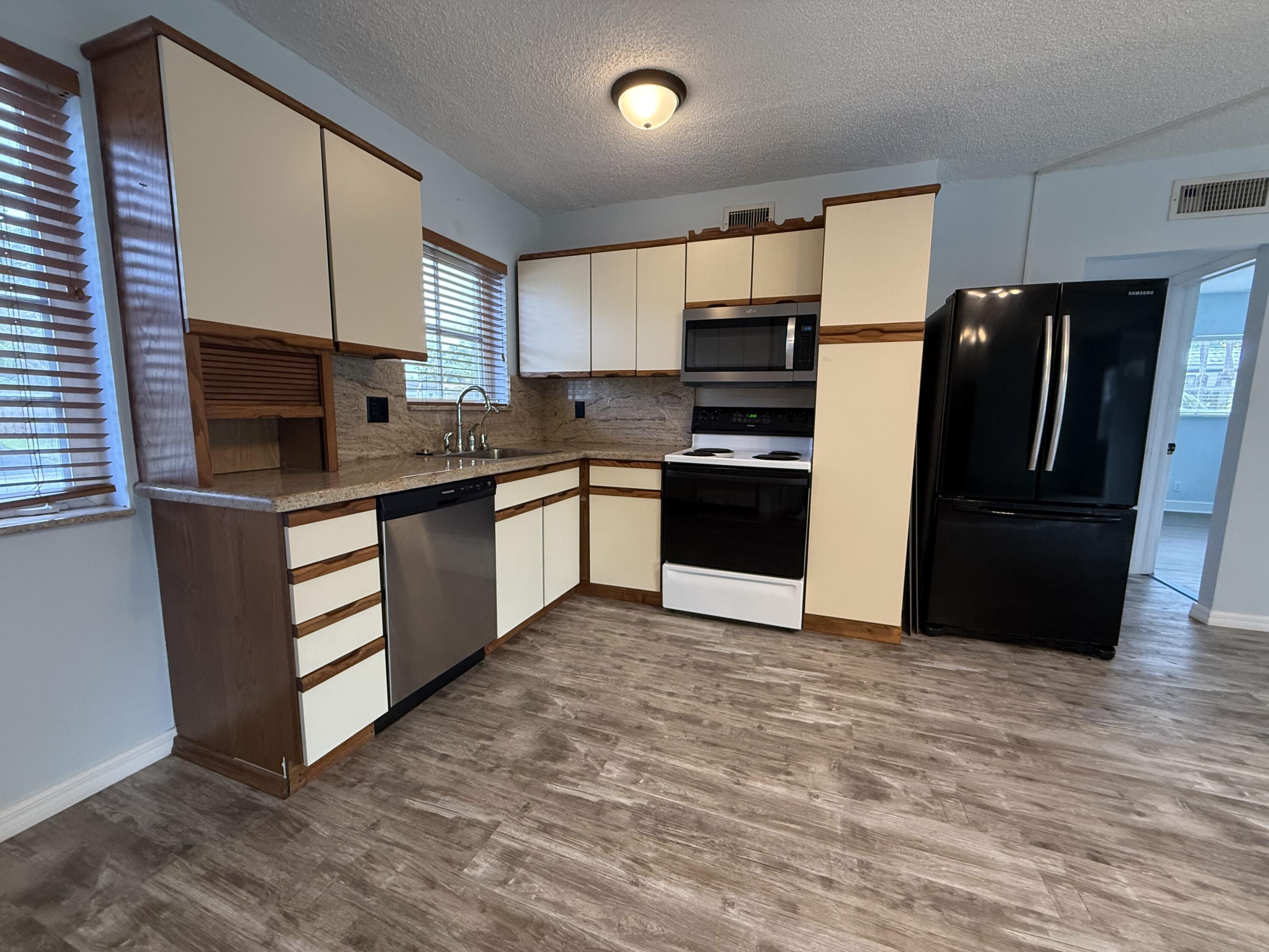 500 Southwest 15th Street, Unit 109 Pompano Beach, FL 33060 - Photo 17 of 17 a kitchen with stainless steel appliances granite countertop a stove a refrigerator and a sink