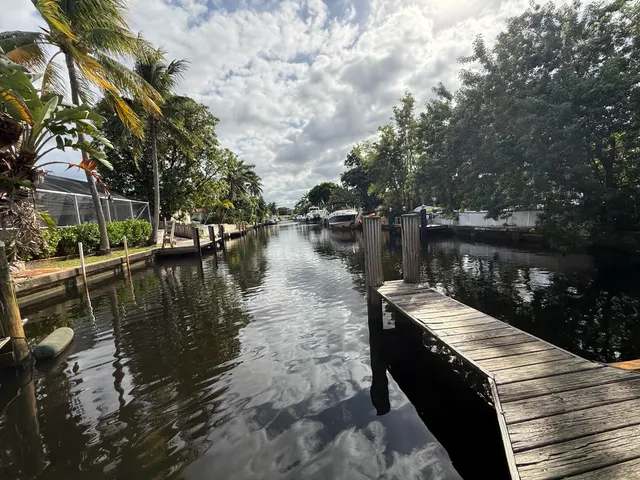 a wooden pier with boats in a lake