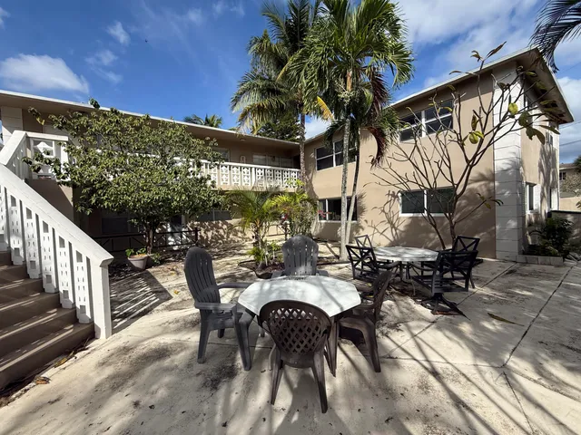 a view of a patio with table and chairs with wooden floor and fence