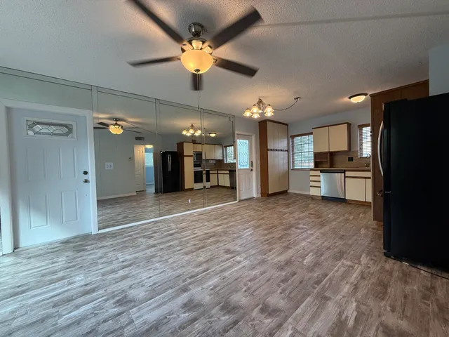 a view of a kitchen with a refrigerator and a microwave