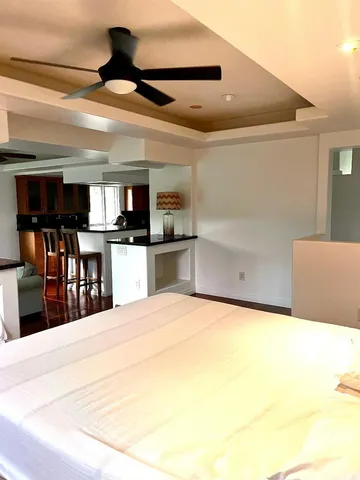 a large white kitchen with kitchen island a sink stainless steel appliances and cabinets