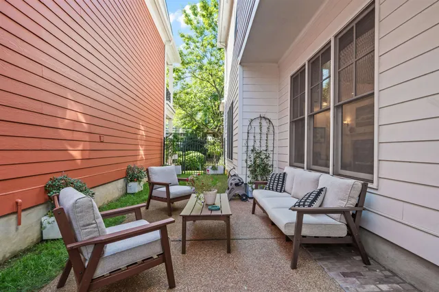 a view of a patio with couple of chairs and a potted plant