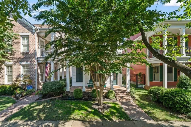 a view of a patio with table and chairs and potted plants and large trees